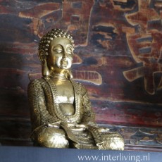 Een goudkleurige boeddha in meditatie houding voor een zen styling in huis