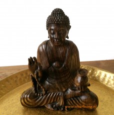 Houten boeddha-beeldje in zittende pose van hout in lotus meditatie met mudra hand