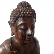 Zittend houten boeddhabeelden in meditatie
