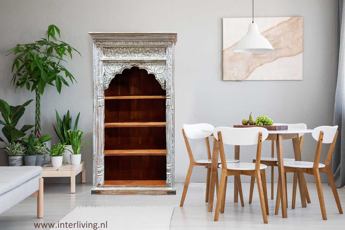 woonkamer met wit, grijs en naturel hout pallet en een wit verweerde vintage open bogen India kast