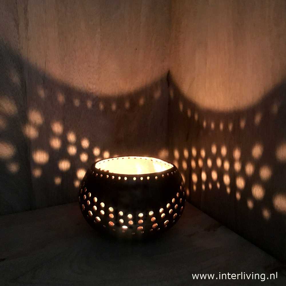 Bali style waxinehouder kokosnoot bowl met fijne gaatjes patronen die speels licht reflecteert